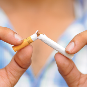 The person holds the cigarette with their fingers and breaks it.